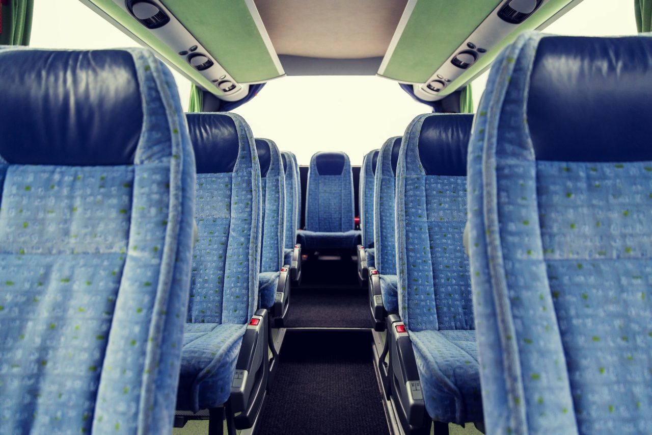 Forward-facing seating down the aisle of a charter bus interior